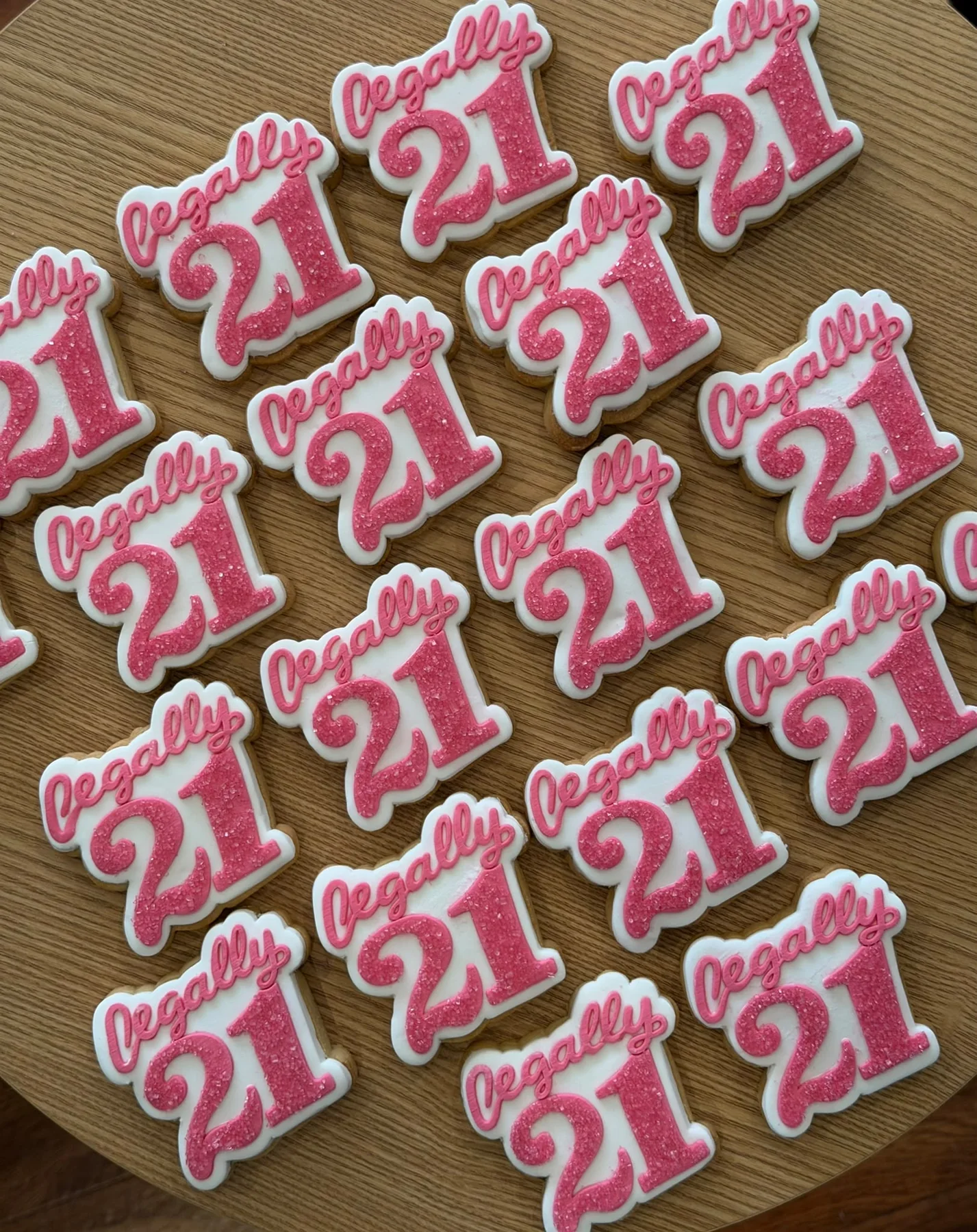 Pink iced cookies created for a twenty-first birthday celebration.