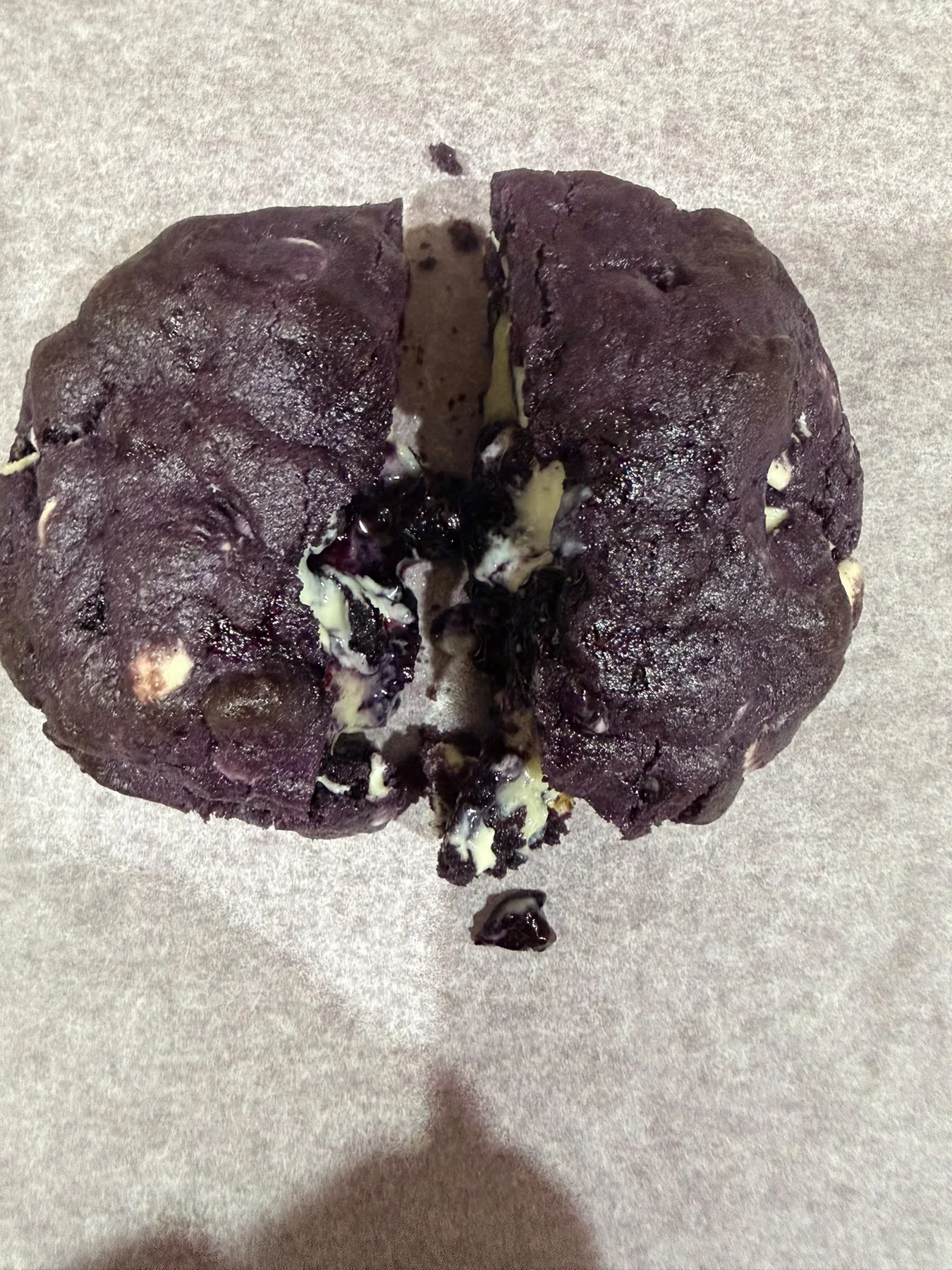 Dark chocolate cookies broken open to show a gooey centre.
