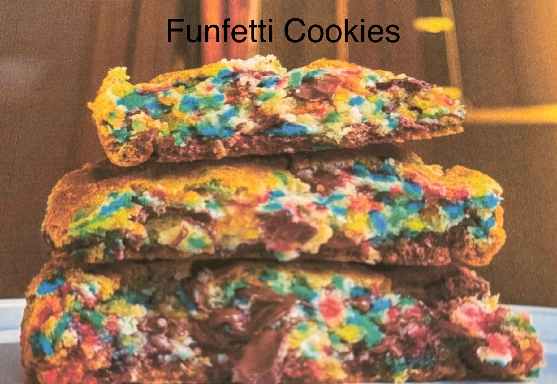 Bright funfetti cookies broken open to show colourful sprinkles.