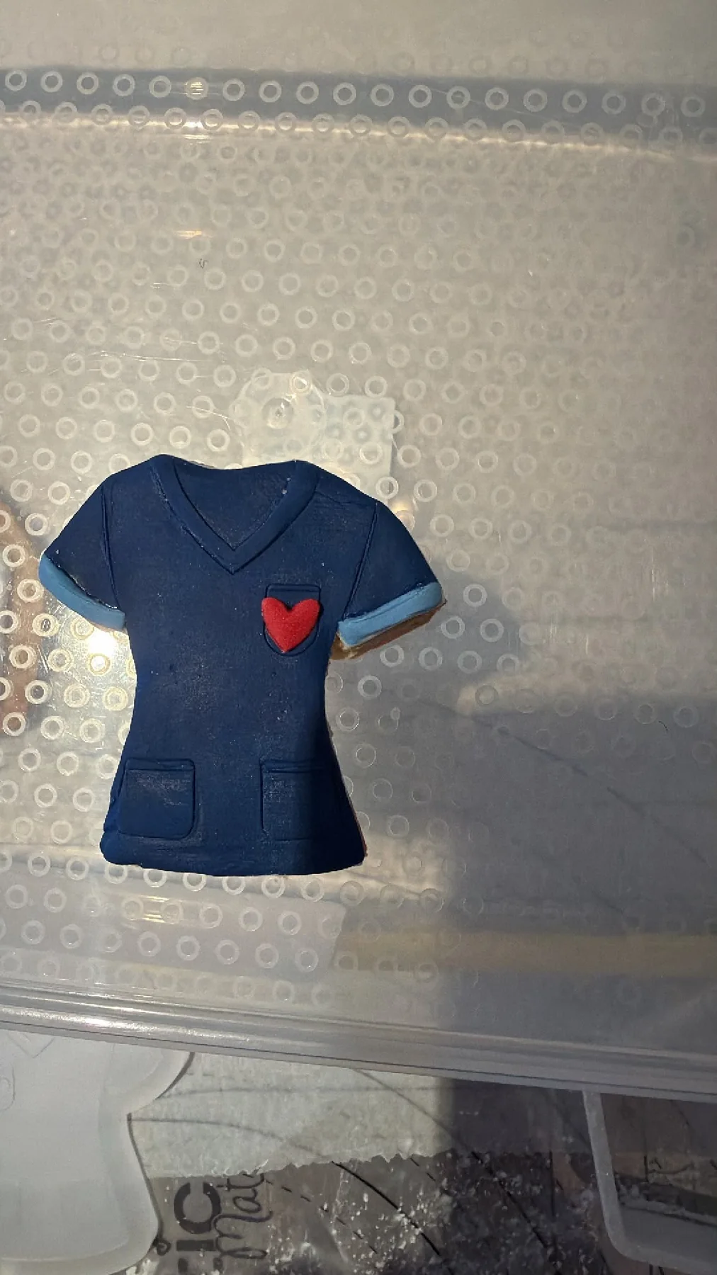 Hand-decorated nurse uniform cookie with a heart detail.
